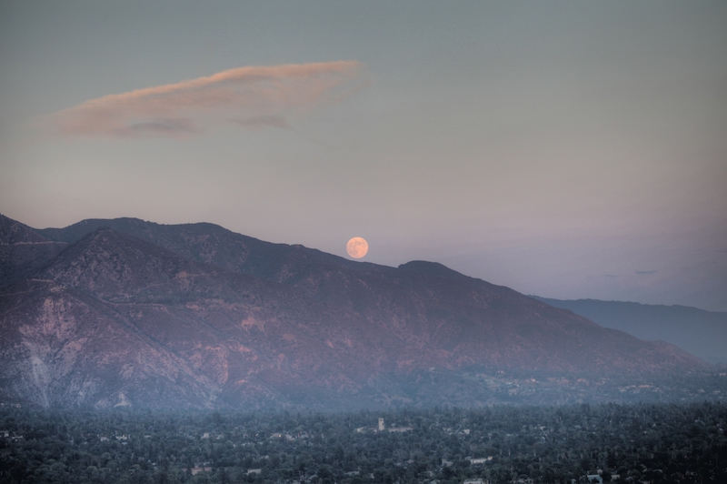 full moon rising over mountains