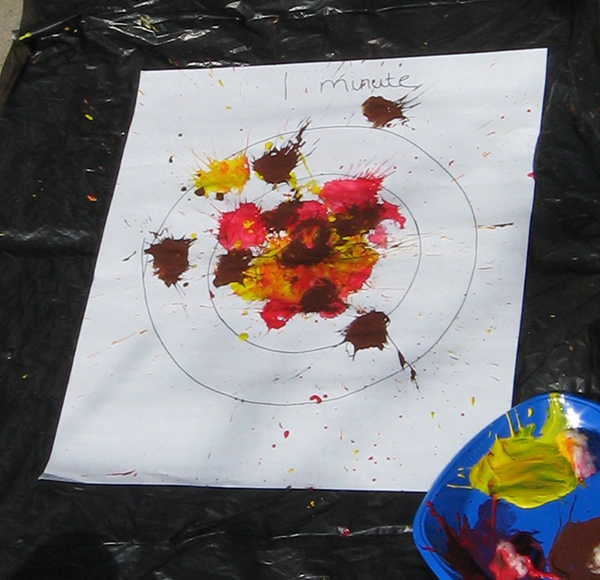 Paper with splashes of red, yellow, and brown paint.