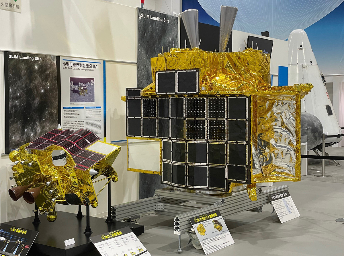 Spacecraft metal object with gold foil on display at an exhibit.