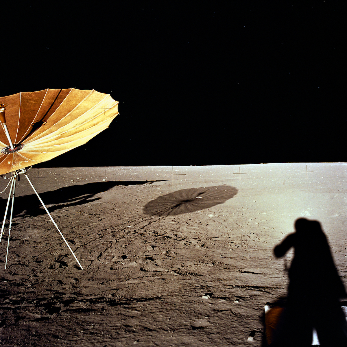 an antenna deployed on the Moon's surface and an astronaut's shadow