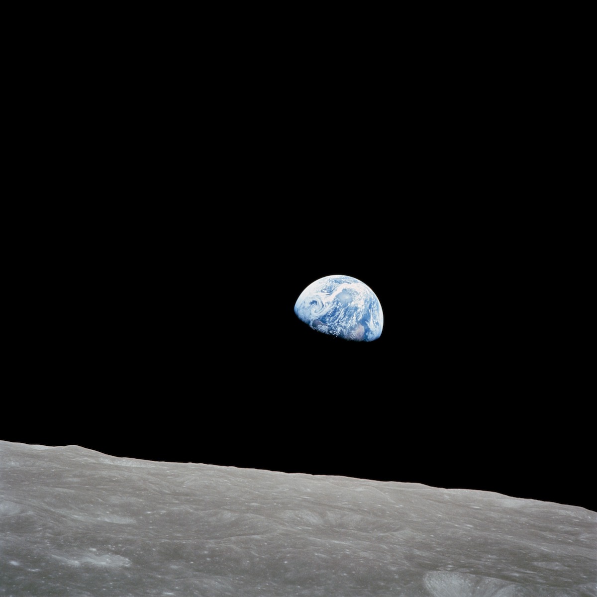 blue Earth against a black sky above the barren lunar surface