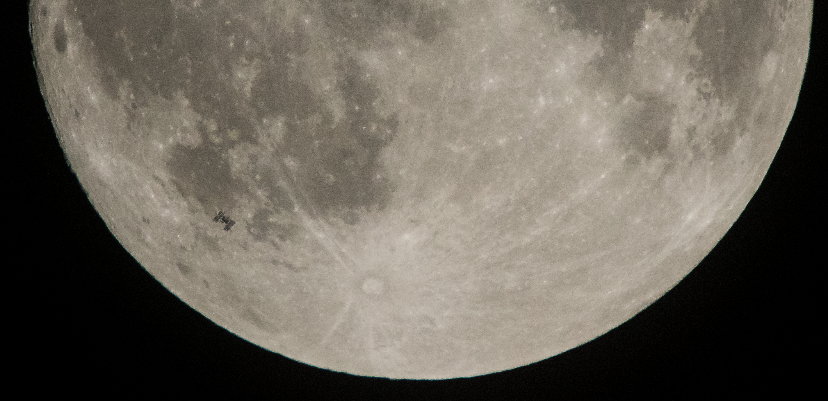 Space Station silhouette in front of Moon.