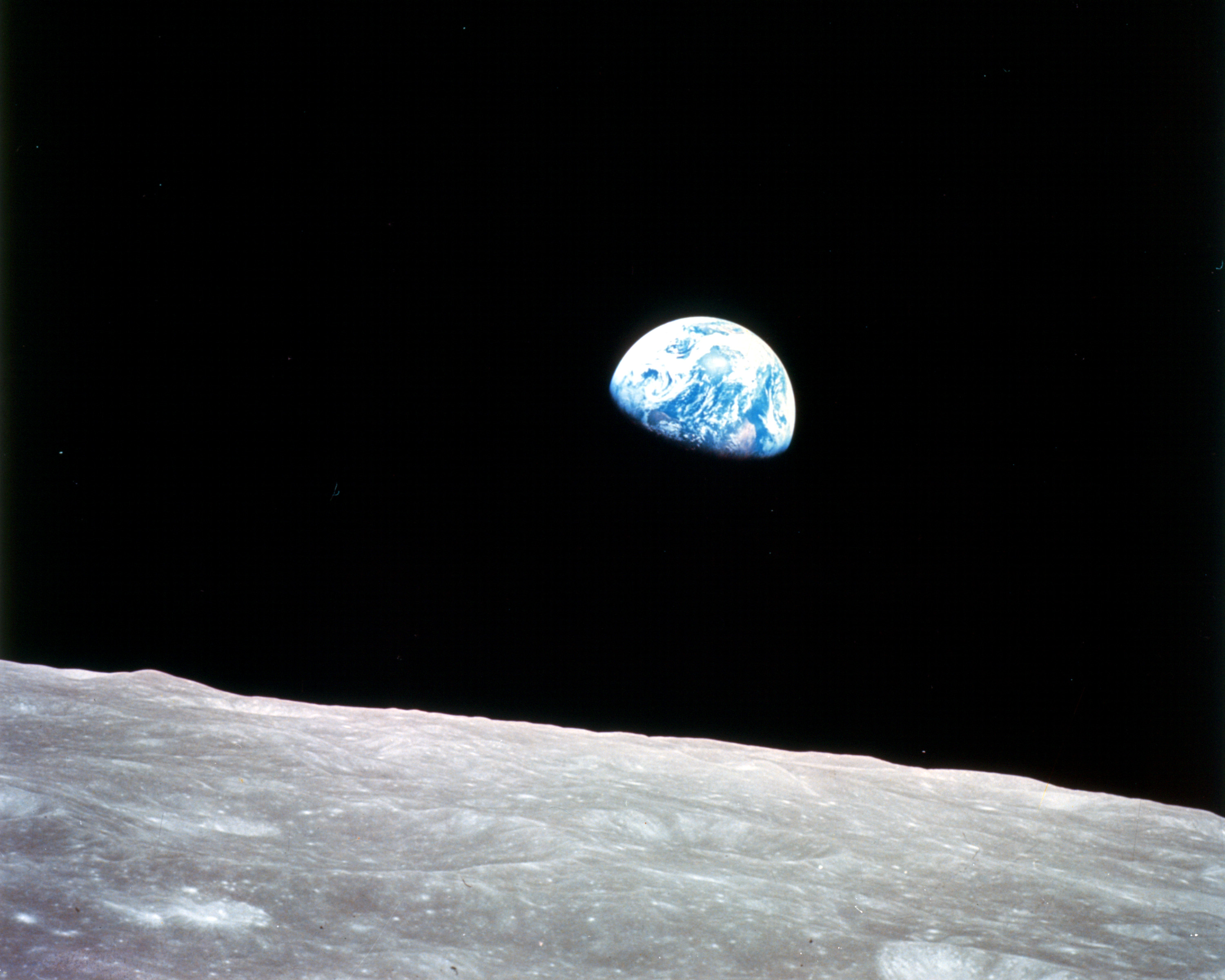 This view of the rising Earth greeted the Apollo 8 astronauts as they came from behind the moon after the lunar orbit insertion burn. 