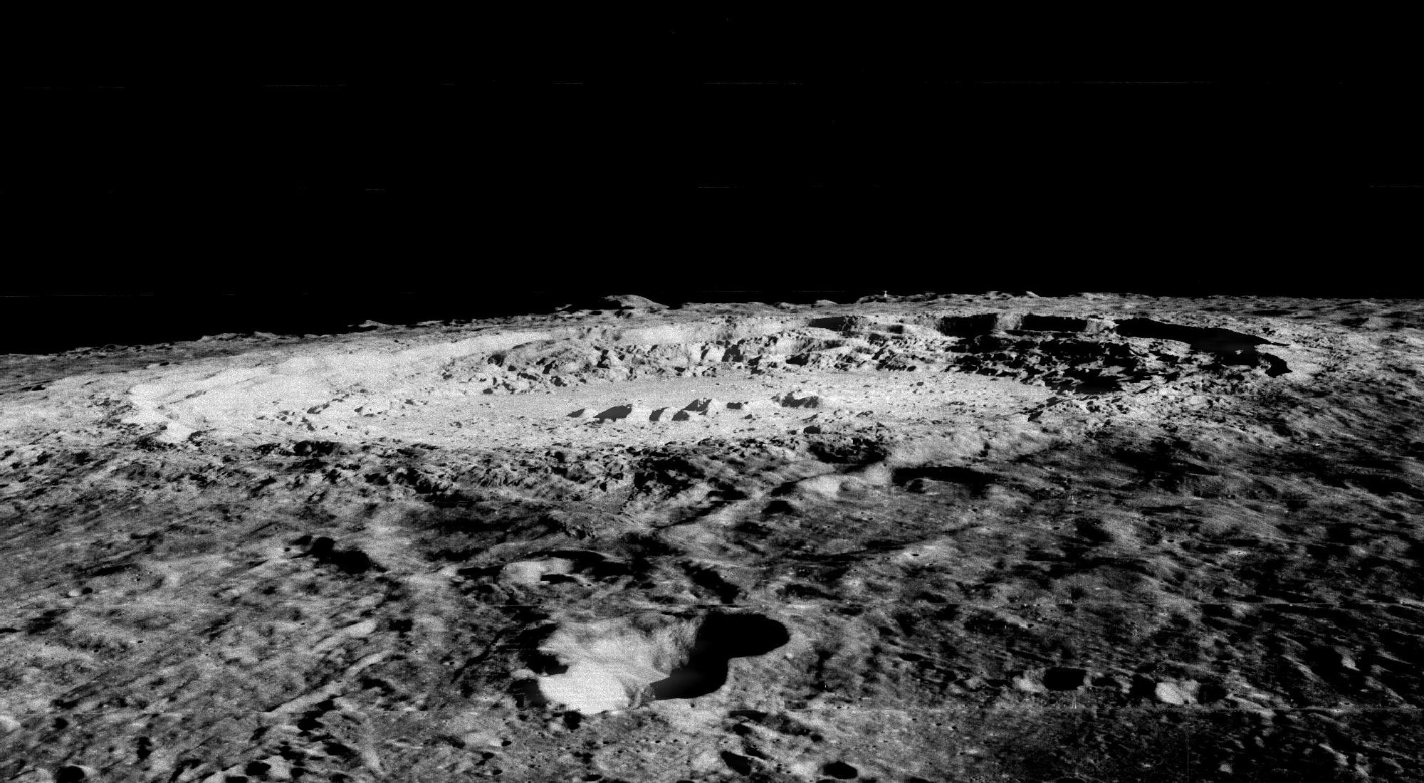 large, rugged impact crater seen nearly edge-on on the lunar horizon