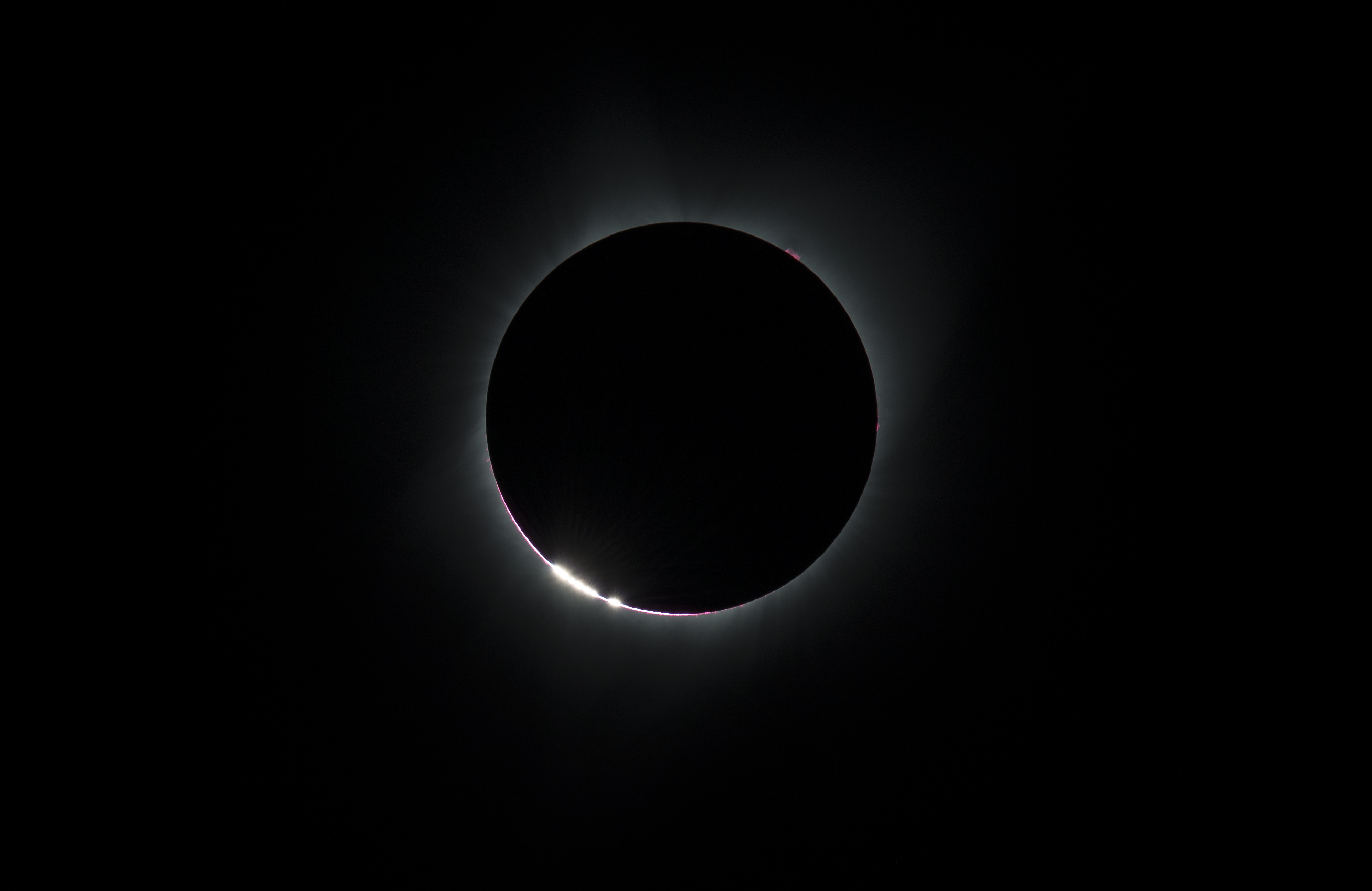 bright glowing "beads" at the edge of the Moon as the Moon nearly completely covers the Sun