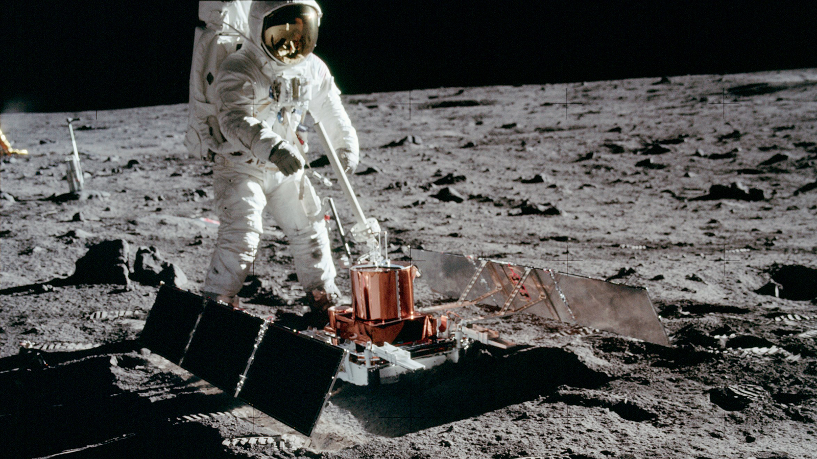 Color image of astronaut with scientific equipment on the moon.