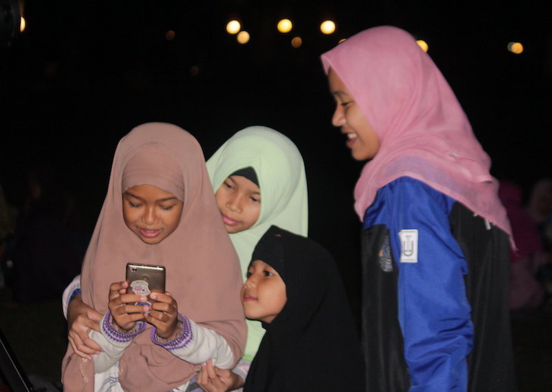 Children gathered around a smartphone