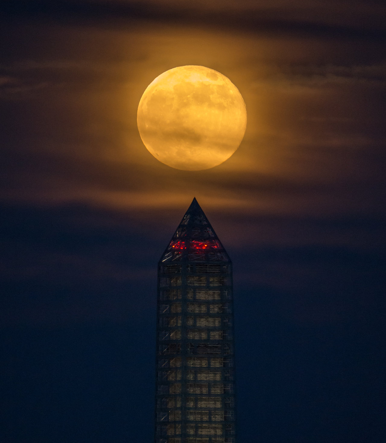 Color image of full moon rising above the Washington Monument.