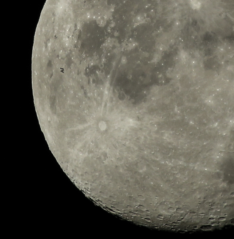 Color image of the Moon as seen from Earth with the International Space Station passing in front of it.