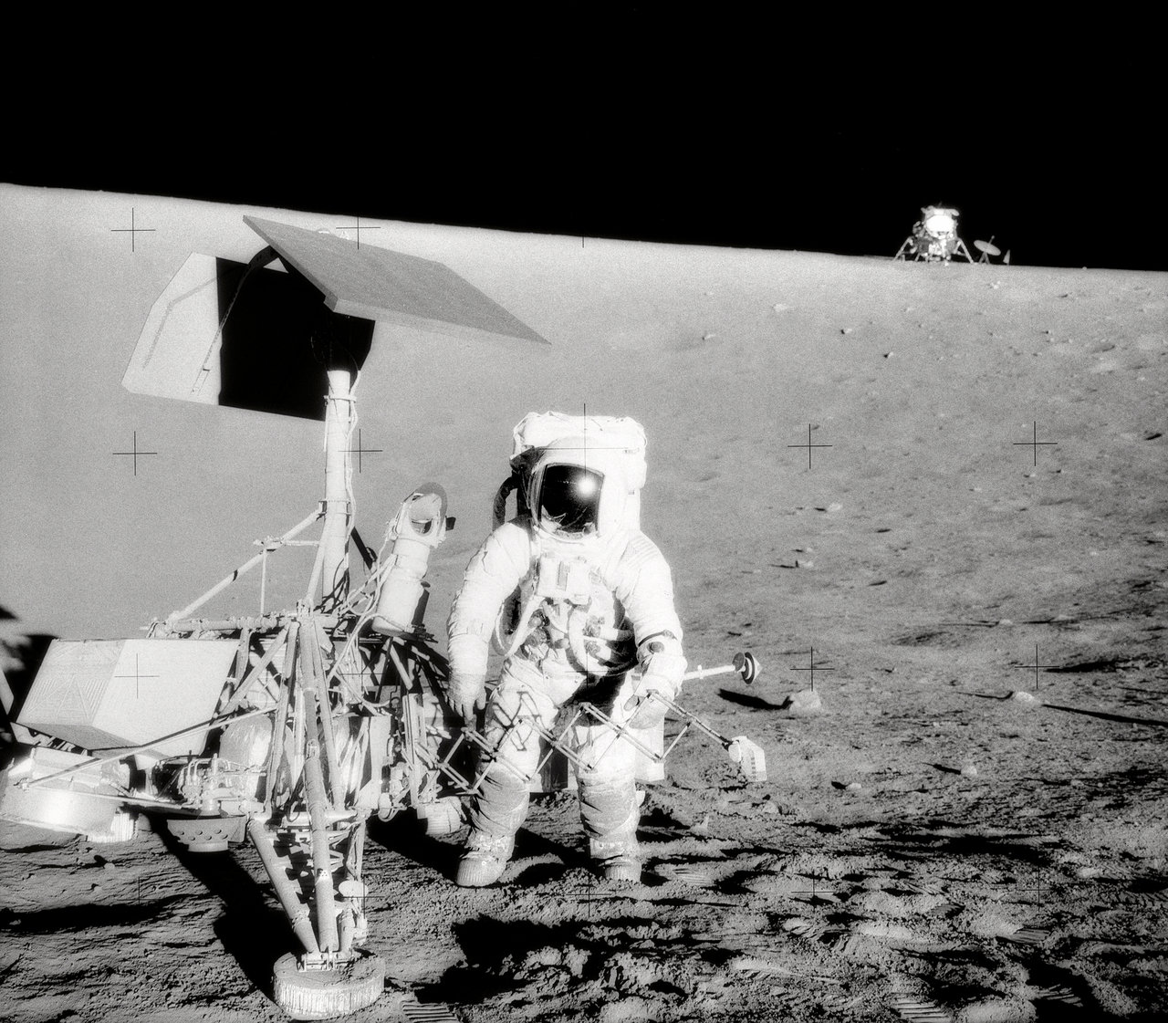 Astronaut and robotic spacecraft on the Moon.
