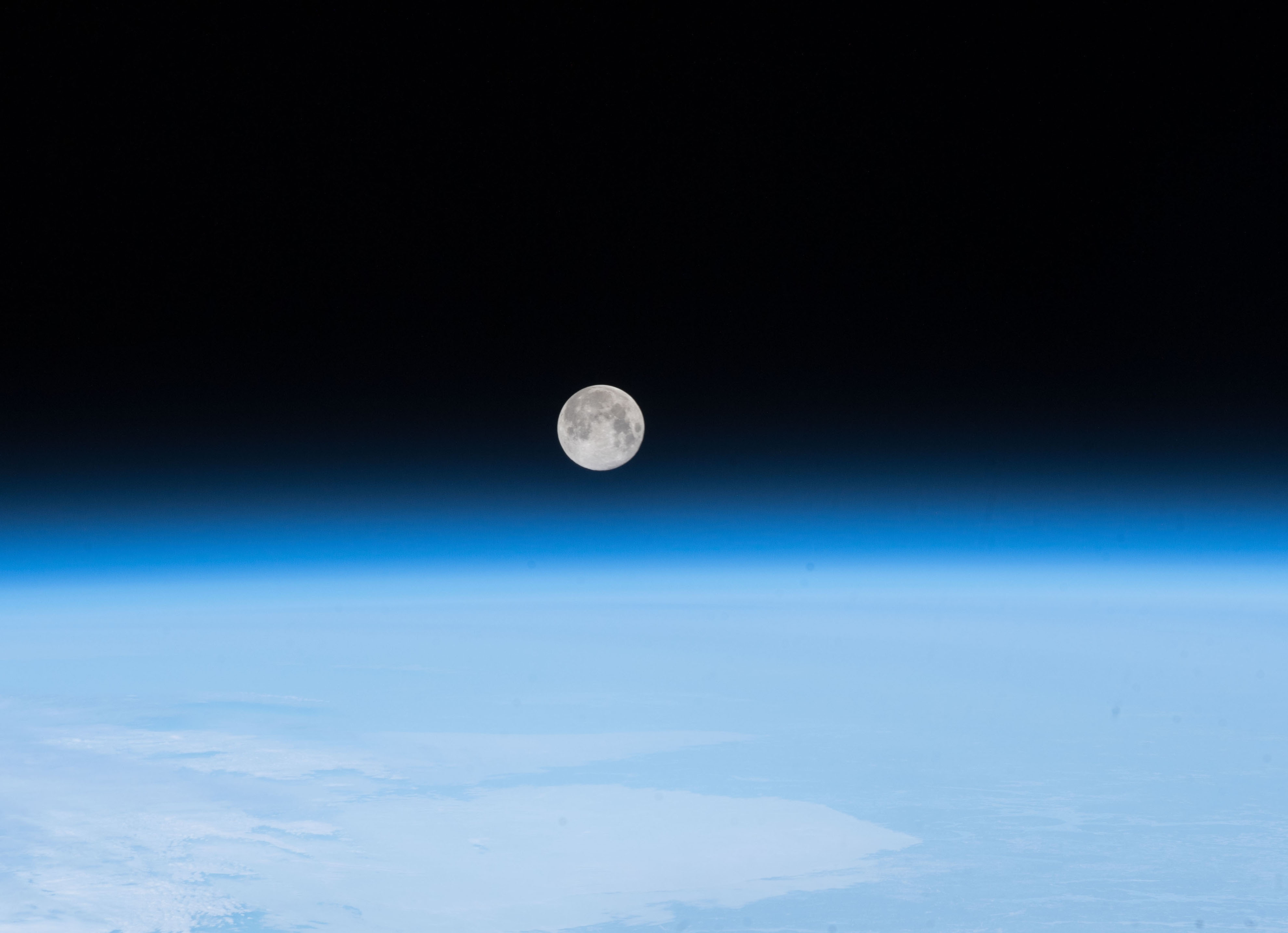 moon over curving horizon and atmosphere of Earth 