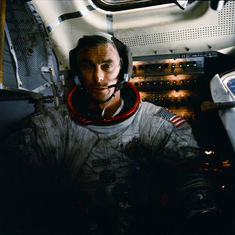 dusty astronaut with helmet removed inside spacecraft